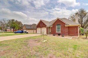 A residential house with a brick exterior, a front yard, and a driveway. - Airy Georgetown Home w/ Fire Pit! (Georgetown)