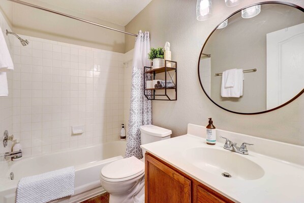 A bathroom with a bathtub, toilet, sink, and a mirror. - Airy Georgetown Home w/ Fire Pit! (Georgetown)