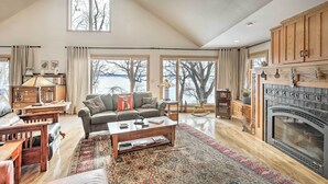 A spacious living room with a fireplace, large windows, and a cozy seating area. - Pet-friendly Family Home Situated on Green Lake! (Green Lake)
