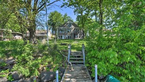 A wooden bridge leading to a house surrounded by lush greenery. - Pet-friendly Family Home Situated on Green Lake! (Green Lake)
