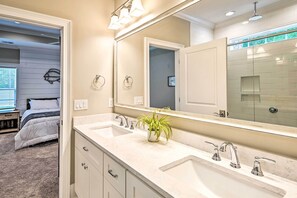 A bathroom with a double sink, a large mirror, and a potted plant. - Charming Pawleys Island Home ~ 4 Mi to Beach! (Pawleys Island)