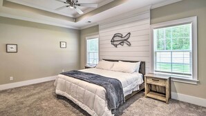 A bedroom with a bed, a nightstand, a ceiling fan, and a wall-mounted fish decoration. - Charming Pawleys Island Home ~ 4 Mi to Beach! (Pawleys Island)