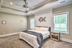 A bedroom with a bed, a nightstand, a ceiling fan, and a wall-mounted fish decoration. - Charming Pawleys Island Home ~ 4 Mi to Beach! (Pawleys Island)