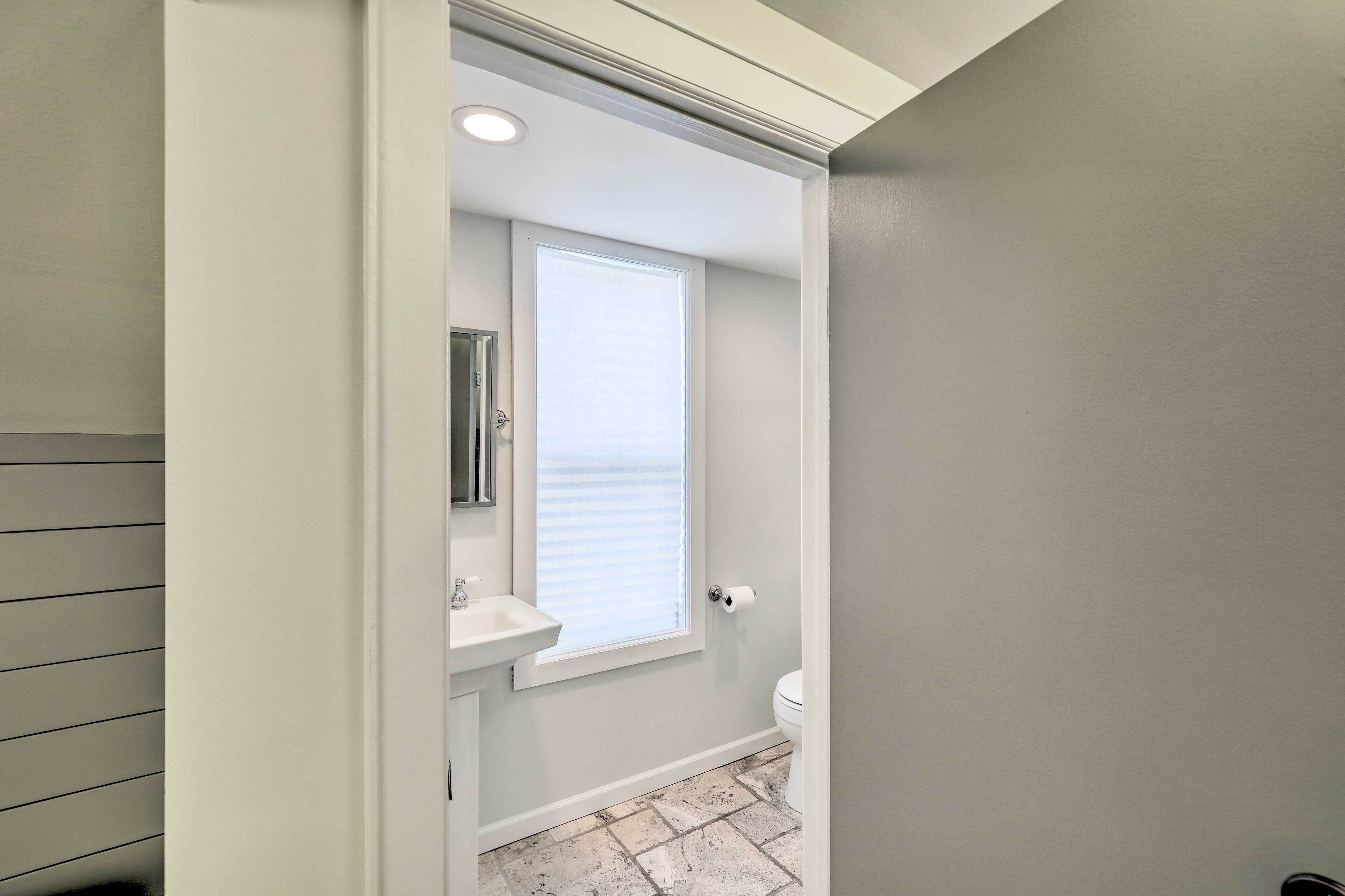 Ein Badezimmer mit Fenster, Waschbecken und Toilette.