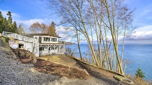 Una cabaña junto al lago con un porche y una terraza, y vistas al lago.
