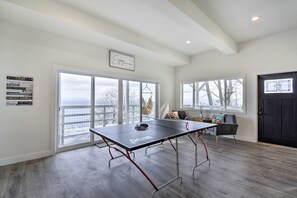 A spacious room with a ping pong table, large windows with a view, and motivational posters on the walls. - Waterfront Kingston Getaway on Puget Sound! (Kingston)