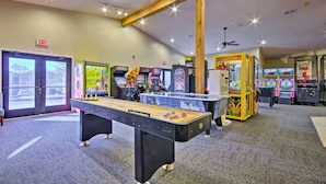 A room with a foosball table, arcade games, and an exit sign. - Vibrant Holiday Hills Resort Condo w/ Balcony (Branson)