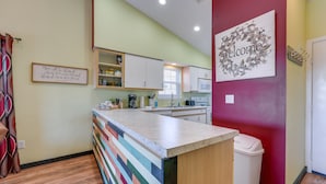A modern kitchen with a striped backsplash, a welcome sign, and a microwave. - Vibrant Holiday Hills Resort Condo w/ Balcony (Branson)