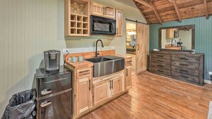 A compact kitchen with wooden cabinets, a stainless steel sink, and a coffee maker. - Cassopolis 'the Cabin' Retreat: Lake Access! (Cassopolis)