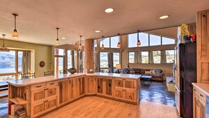 A spacious kitchen with wooden cabinetry, a large island, and a dining area with a sofa and table.
