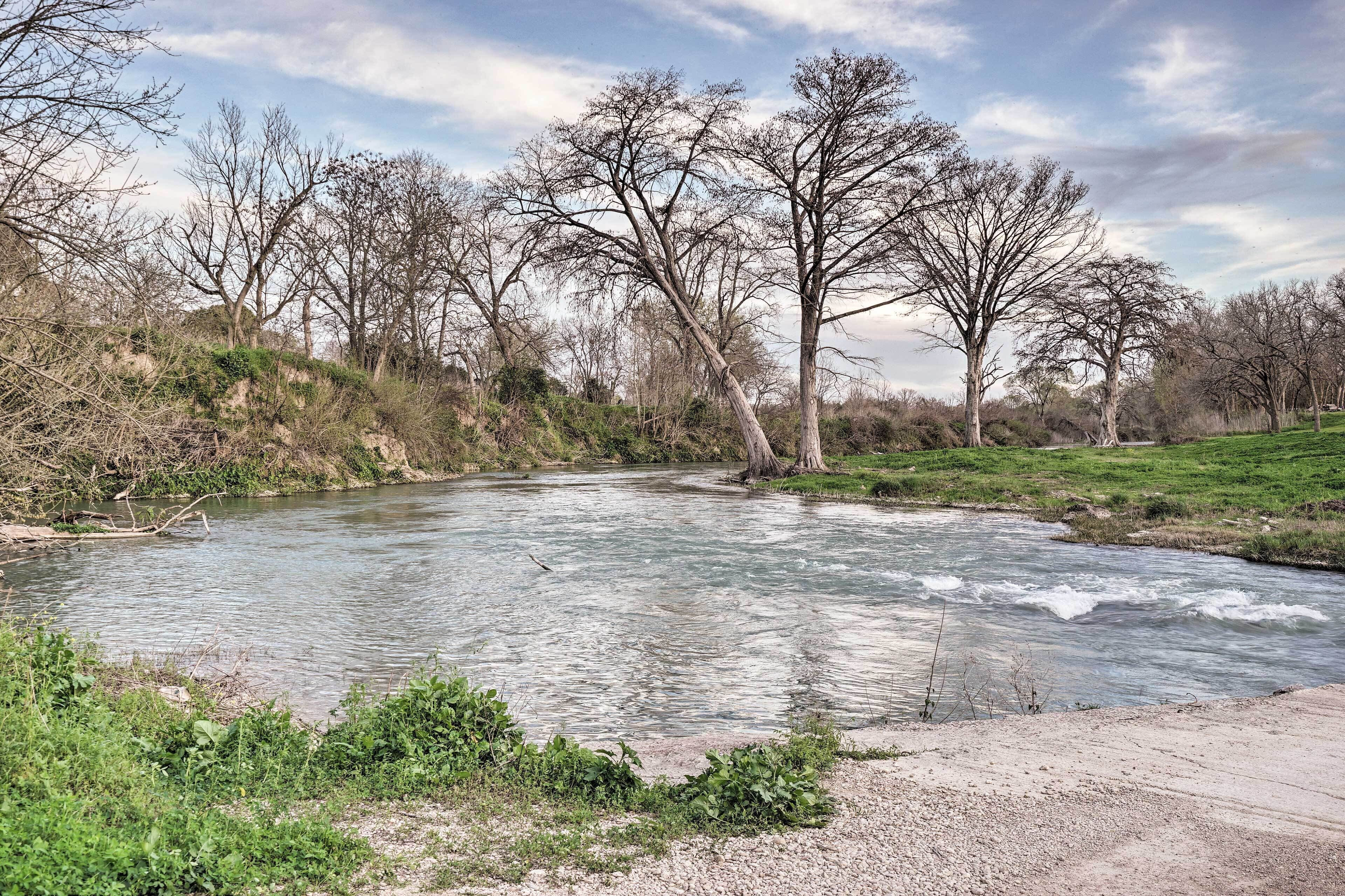A river with trees and a grassy bank.