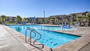 A swimming pool with blue tiles, a metal ladder, and blue lounge chairs. - St George Area Townhome w/ Patio + Pool Access (Washington)