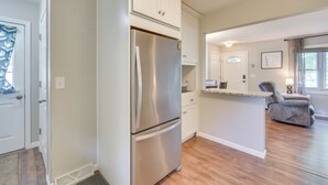 A modern kitchen with white cabinetry, a stainless steel refrigerator, and a wooden floor. - Sunny Cloquet Home - 2 Mi to St. Louis River! (Cloquet)
