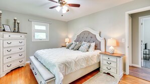 A bedroom with a bed, nightstands, a dresser, a ceiling fan, and a window. - Sunny Cloquet Home - 2 Mi to St. Louis River! (Cloquet)