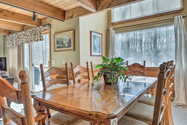 A wooden dining table with chairs, a potted plant, and framed pictures on the walls. - Cozy Conway Area Home ~ 4 Mi to Cranmore Mountain! (Intervale)