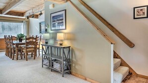 A dining area with wooden chairs and a table, a staircase, and a framed picture on the wall. - Cozy Conway Area Home ~ 4 Mi to Cranmore Mountain! (Intervale)