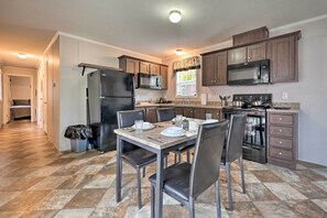 Enjoy meal preparation and dining in this stylish kitchen with a dining table and chairs, double oven, and microwave.