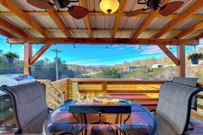 A covered outdoor seating area with a fire pit, wooden deck, and a view of the surrounding landscape. - Studio w/ Loft, Hot Tub & Views in Marshall! (Marshall)