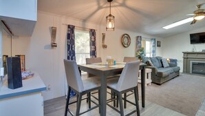 A dining area with a table, chairs, and a hanging light fixture.