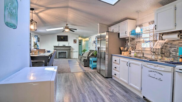 A kitchen with a skylight, a ceiling fan, and a refrigerator.