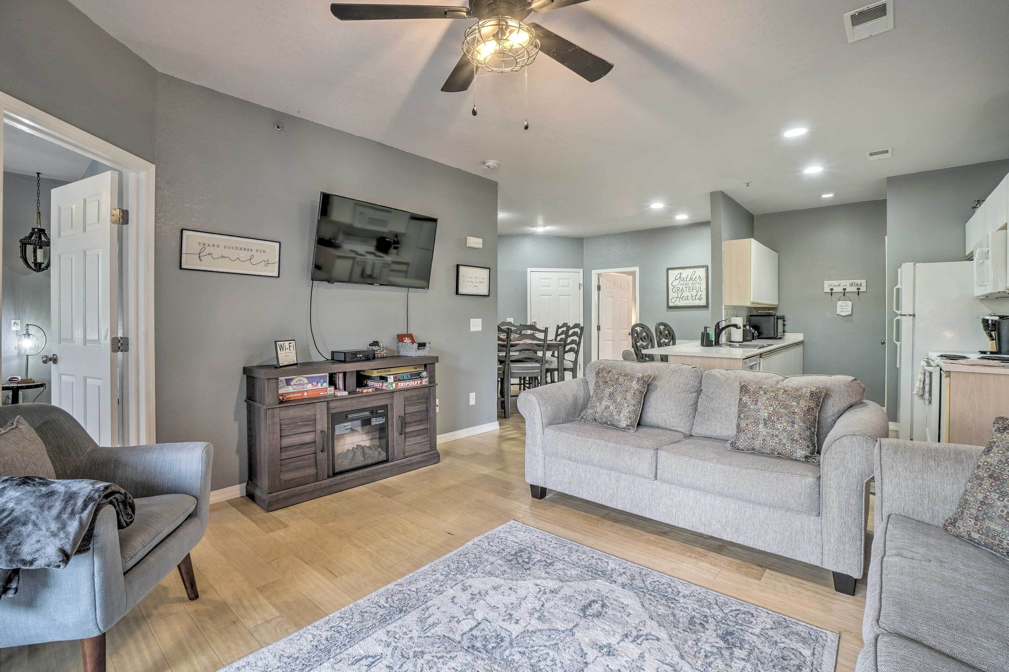 A modern living room with a grey sofa, a coffee table, and a TV mounted on the wall.