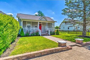 A single-story house with a front porch, a red door, and a well-maintained lawn. - Family-friendly Home Near Noblesville Square! (Noblesville)