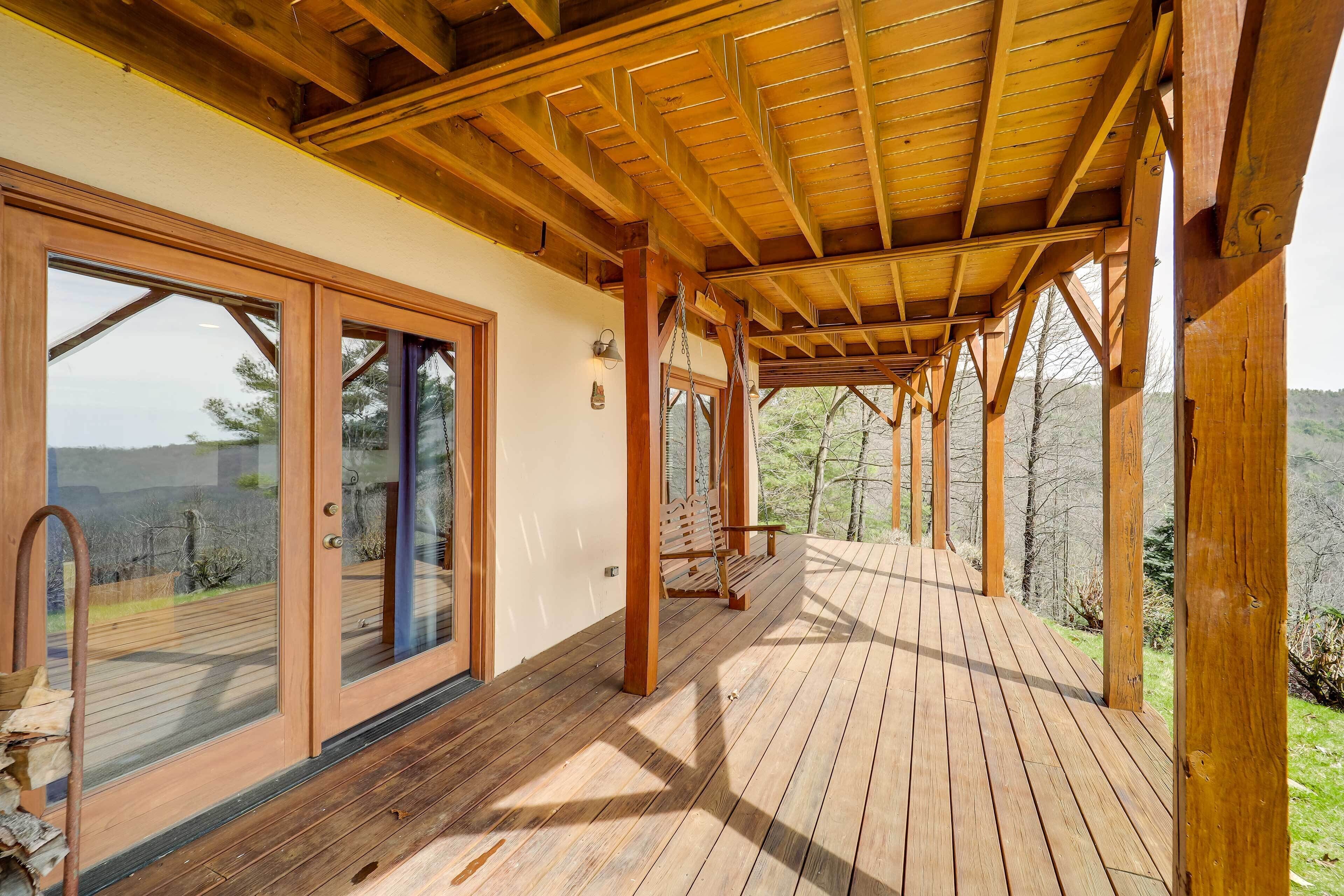 A wooden deck with glass doors leading to a covered area.
