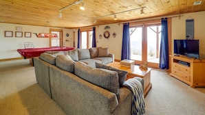 A cozy living room with a wooden ceiling, a pool table, a sofa, a television, and a fireplace. - Smoky Mountain Vacation Rental w/ Large Deck! (Deep Gap)