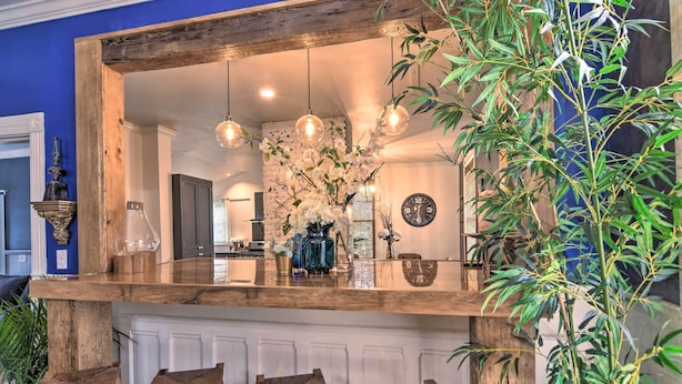 Una cocina con una isla de madera, luces colgantes y un reloj en la pared.