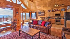 Una cabaña espaciosa con interior de madera, zona de comedor, sofá y cocina.