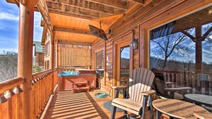 Una cabaña de madera con terraza, jacuzzi y mobiliario de exterior.