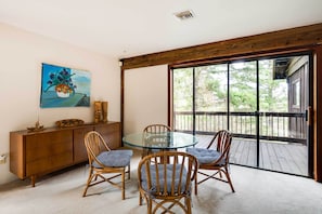 A dining area with a glass table and wicker chairs, a wooden cabinet, and a painting on the wall. - Peaceful Applegate River Valley Sanctuary! (Grants Pass)