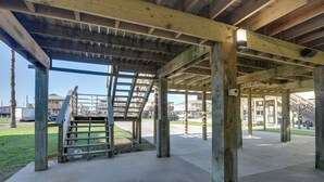 An open wooden structure with a concrete floor, possibly a covered walkway or patio area. - Walk to Shore & Restaurants: Surfside Beach Home! (Freeport)