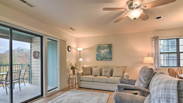 A living room with a sofa, a chair, a coffee table, a floor lamp, and a painting on the wall.