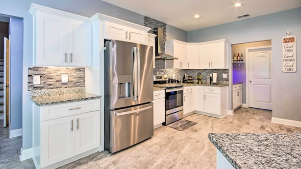 A modern kitchen with white cabinets, stainless steel appliances, and a granite countertop. - Bright Hopkins Home w/ Game Room & Fire Pit! (Hopkins)