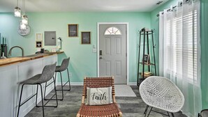A kitchen with a wooden countertop, bar stools, a hanging light fixture, and a door with a window. - Pet-friendly Fayetteville Vacation Rental! (Fayetteville)