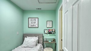 A bedroom with a bed, a bedside table with a mirror, and a framed quote on the wall. - Pet-friendly Fayetteville Vacation Rental! (Fayetteville)