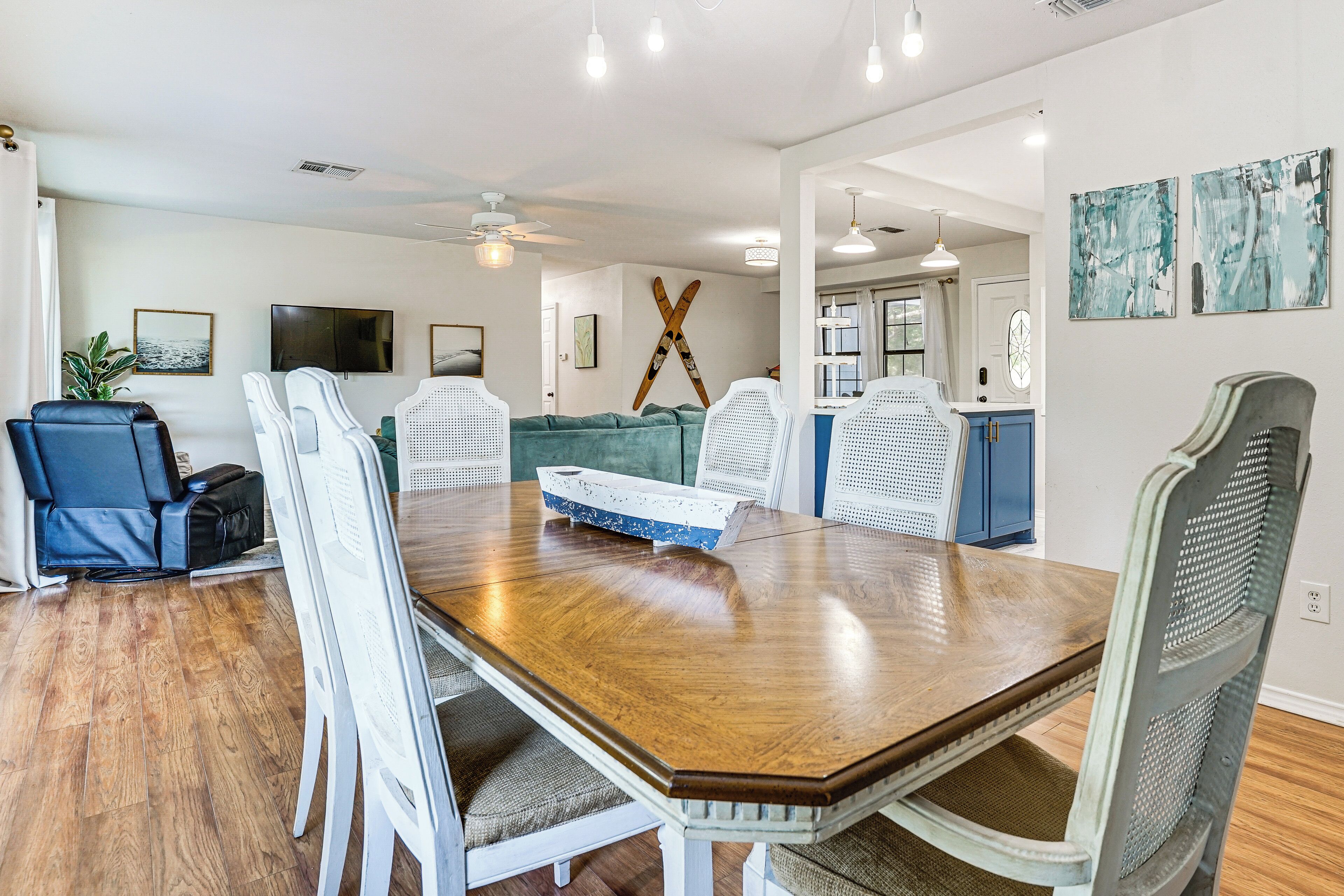 A dining area with a wooden table, white chairs, and a blue sofa.