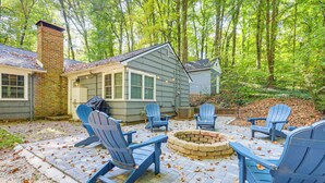A patio with Adirondack chairs, a fire pit, and a brick fireplace. - Family-friendly Knoxville Home: Close to UT! (Knoxville)