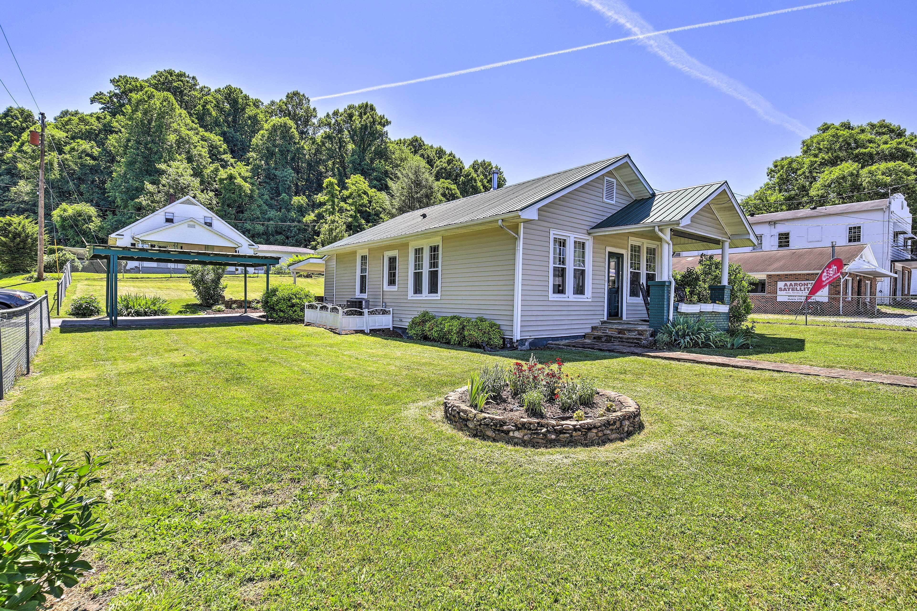 A single-story house with a front porch, a small garden, and a clear sky.