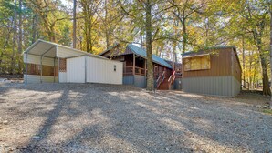 A campground with multiple cabins, a covered area, and a staircase leading to a deck. - Private Hot Tub & Deck! Broken Bow Group Getaway (Broken Bow)