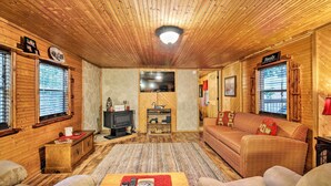 A cozy wooden cabin interior with a fireplace, a television, and a comfortable seating area. - Private Hot Tub & Deck! Broken Bow Group Getaway (Broken Bow)