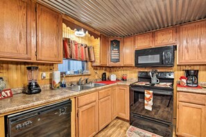 A kitchen with wooden cabinets, a microwave, a stove, and a dishwasher. - Private Hot Tub & Deck! Broken Bow Group Getaway (Broken Bow)