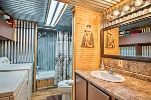 A compact bathroom with a wooden vanity, a sink, a toilet, and a shower area. - Private Hot Tub & Deck! Broken Bow Group Getaway (Broken Bow)