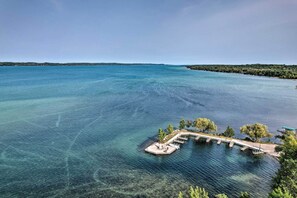 On peut admirer une vue dégagée sur un lac, avec une jetée qui s’avance dans l’eau, le tout étant entouré d’arbres et bordé par une rive éloignée.