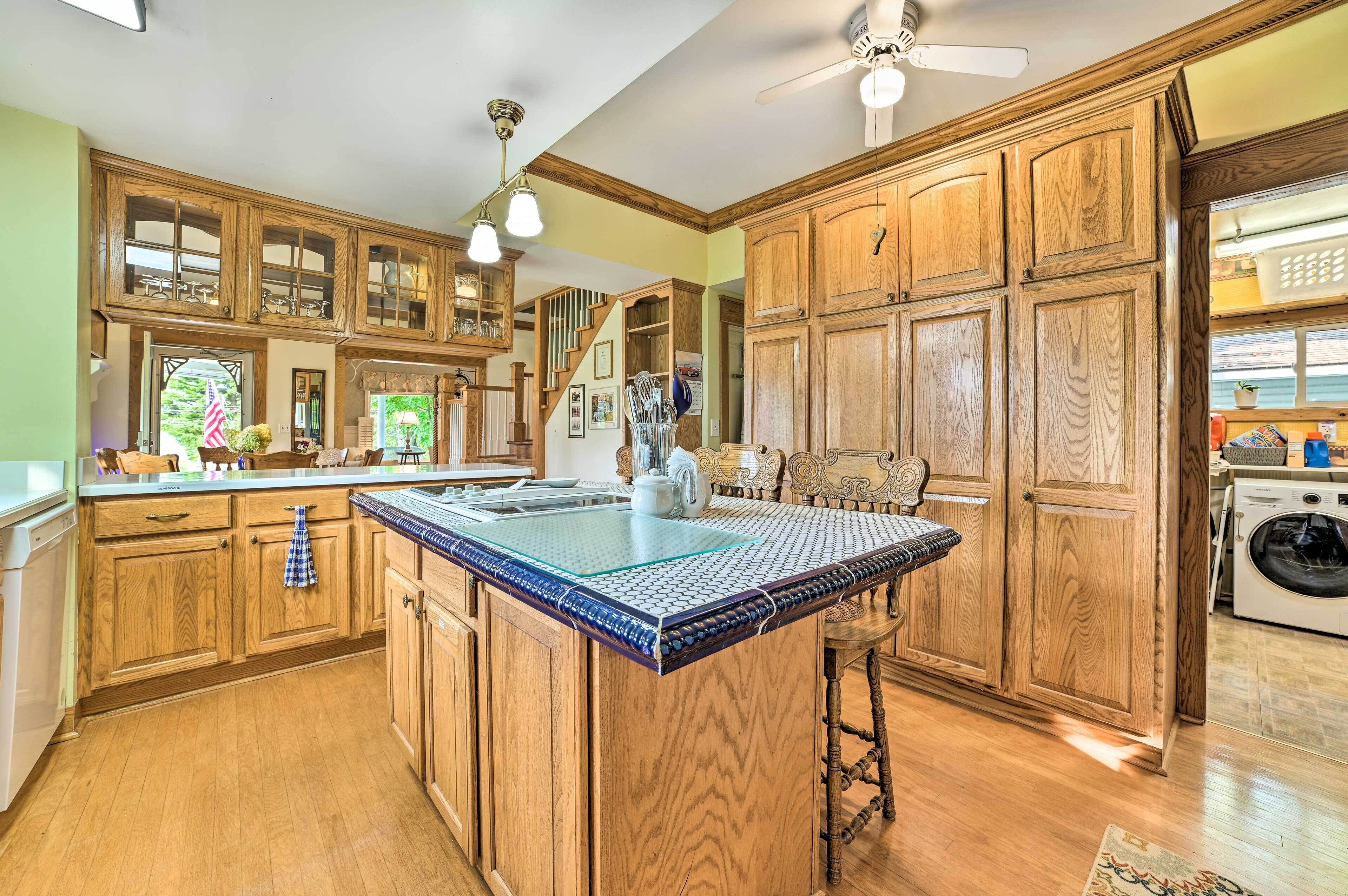 A kitchen with wooden cabinets, a central island, and a ceiling fan.