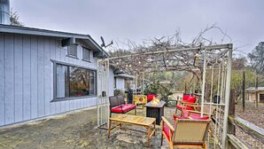 Un espace extérieur aménagé avec du mobilier de jardin, une pergola et un sol en pierre.