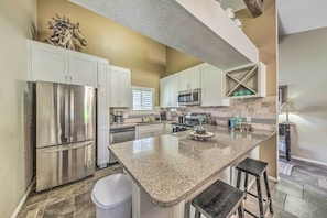 A modern kitchen with stainless steel appliances, white cabinets, and a granite countertop. - 'villa Con Vista' w/ Putting Green & Hot Tub! (Ruidoso)