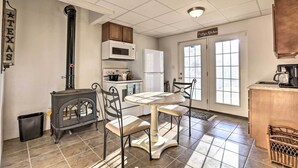A kitchen with a wood stove, white cabinets, a microwave, and a refrigerator. - Family Farmhouse on 160-acre Ranch w/ Hiking Trail (Lawrenceburg)