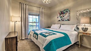 A bedroom with a bed, a window with curtains, a nightstand, a lamp, a painting, and a mirror. - Family Farmhouse on 160-acre Ranch w/ Hiking Trail (Lawrenceburg)